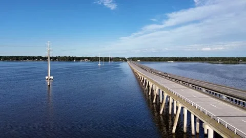 Wright Memorial Bridge Over Calm Ocean Under Bright Sunlight With Reflective Stock Footage 317651676