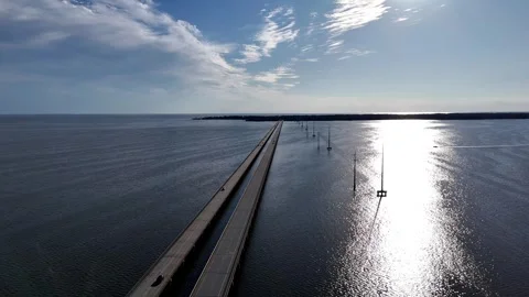 Wright Memorial Bridge Over Calm Ocean Under Bright Sunlight With Reflective Stock Footage 317651734