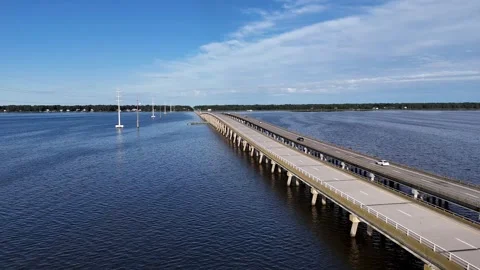 Wright Memorial Bridge Over Calm Ocean Under Bright Sunlight With Reflective Stock Footage 317651843