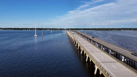 Wright Memorial Bridge Over Calm Ocean Under Bright Sunlight With Reflective Stock Footage 317651940