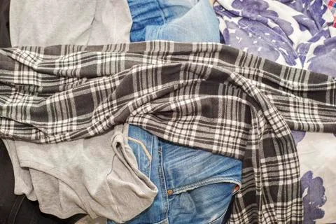 Wrinkled clothes lying on sofa Stock Photos