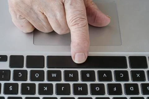 Wrinkled hand using computer Stock Photos