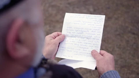 Wrinkled hands of elderly man holding handwritten letter Stock Footage 230692047