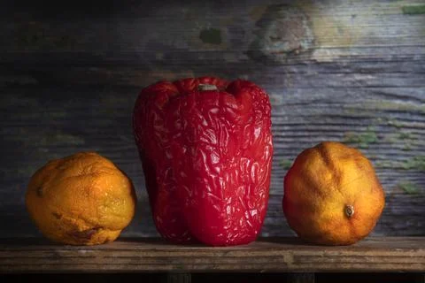 Wrinkled Red Pepper Between Two Dried Lemons Stock Photos