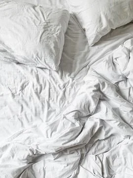 Wrinkled White Bedding with Pillows Stock Photos