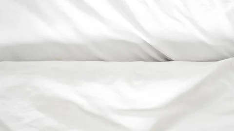 Wrinkled white bedsheet background symbolizing comfort, warmth, and relaxatio Stock Photos