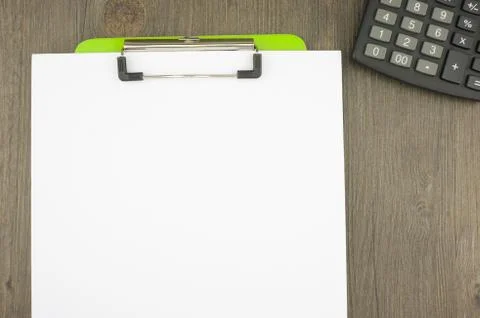 Write blank paper clip on green clipboard with calculator Stock Photos