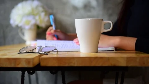 Write a book and have coffee in a coffee shop. Stock Footage 80411770