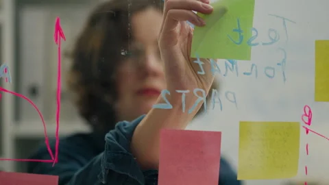 Write, Business project expert glues a sticker, sticks a note in a stylish c Stock Footage 243008979