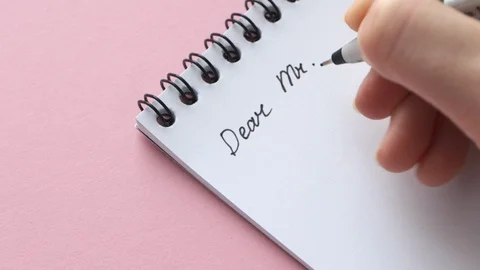 Write Dear Mr. on white note paper. Female hand compose memo or letter, close Stock Footage 129205989