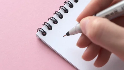 Write Happy Easter on white notepad paper. Female hand do congratulatory note Stock Footage 129205473