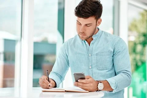 Write it down so you dont forget. a handsome young businessman making notes Stock Photos