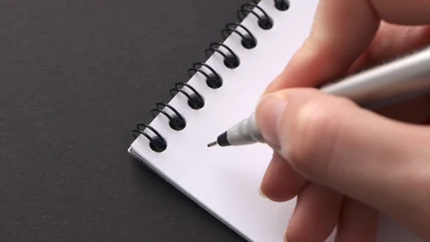 Write spooky Halloween on white notepad paper. Female hand do congratulatory Stock Footage 129205719