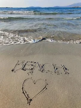 Write the word on the sandy beach and drawing a heart Stock Photos