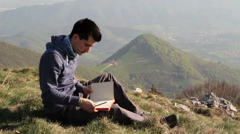 Write in your journal your thoughts on a mountain top Stock Footage 49779019