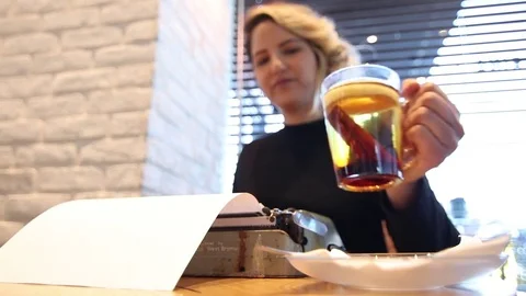 Writer in a cafe drinking cinnamon cider Stock Footage 72275837