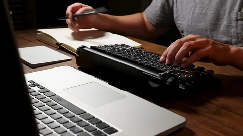 A Writer Takes Notes and Types On Typewriter-style Keyboard. 1080p Stock Footage 113916569