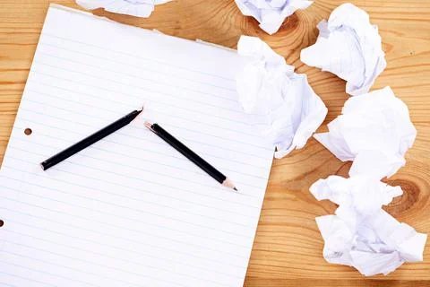 Writers block. a broken pencil and notepad surrounded by crumpled paper. Stock Photos