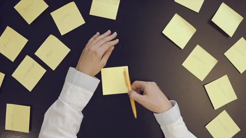 Writes notes on yellow stickers. Stock Footage 87907299