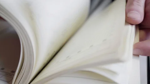 Writes a pen in his diary, looking for entries in a notebook. Video stock 107071598