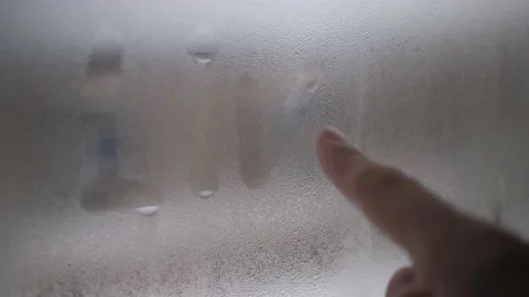 Writes the word live on the window with your finger. The window was fogged up Stock Footage 146657571