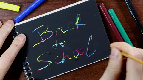 Writing back to school on black scratch book Stock Footage 309733778