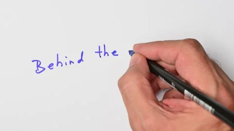 Writing with a blue marker the sentence: Behind the eight ball Stock Footage 221783019