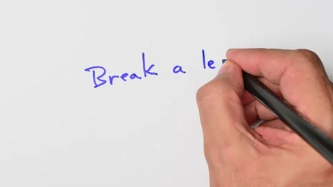 Writing with a blue marker the sentence: Break a leg Stock Footage 221782995