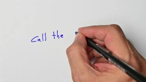 Writing with a blue marker the sentence: Call the ambulance Stock Footage 221781115