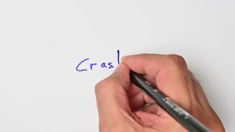 Writing with a blue marker the sentence: Crash Stock Footage 221782214