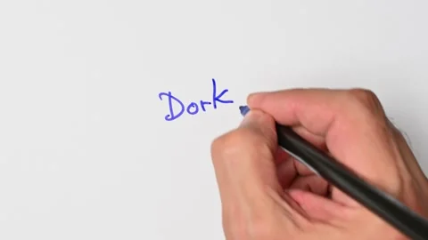Writing with a blue marker the sentence: Dork Stock Footage 221782560