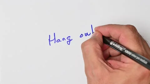 Writing with a blue marker the sentence: Hang out Stock Footage 221781990