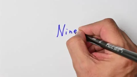 Writing with a blue marker the sentence: Nine Stock Footage 221784024
