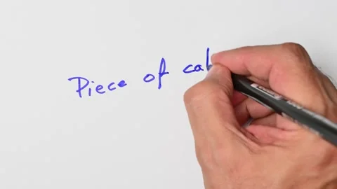 Writing with a blue marker the sentence: Piece of cake Stock Footage 221782779