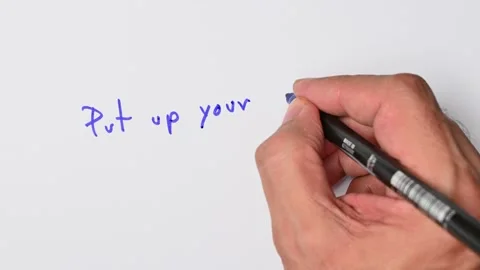 Writing with a blue marker the sentence: Put up your dukes Stock Footage 221783343