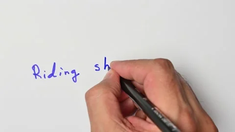 Writing with a blue marker the sentence: Riding shotgun Stock Footage 221783828