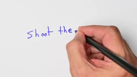 Writing with a blue marker the sentence: Shoot the breeze Stock Footage 221783029