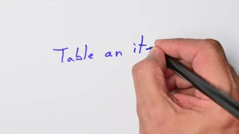Writing with a blue marker the sentence: Table an item Stock Footage 221783366