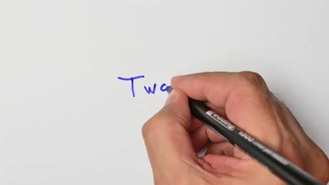 Writing with a blue marker the sentence: Two Stock Footage 221783848