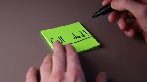 Writing "Call dad" on a post-it note Stock Footage 147137651