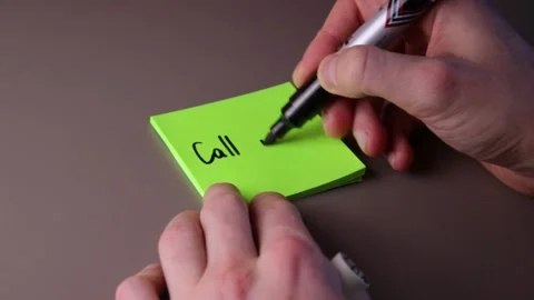 Writing "Call mum" on a post-it note Stock Footage 147137657
