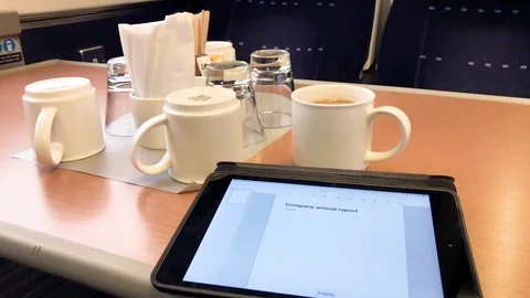 Writing company annual report on a computer tablet, first class train carriage. Stock Footage 101821055