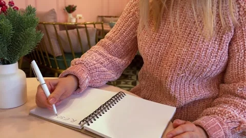 Writing down resolutions for the new year in a notebook. Stock Footage 258598411