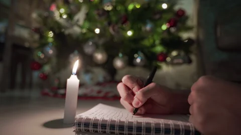 Writing by the Glow of a Christmas Tree Stock Footage 323980623