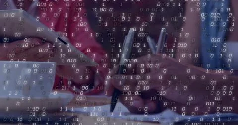Writing hands at desk, pen on notepad, smartphone near white mug, binary Foto stock