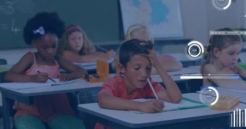 Writing Hispanic boy leaning on arm while scribbling in notebook in classroom, Stock Photos