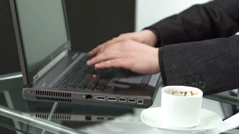 Writing on the keyboard and drinking his morning coffee Video stock 74873739