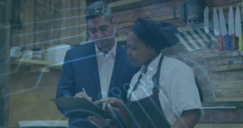 Writing manager noting as chef in uniform pointing at clipboard, checking docs Stock Footage 331614421