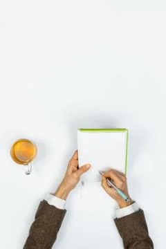 Writing in a note pad, top view.  Stock Photos