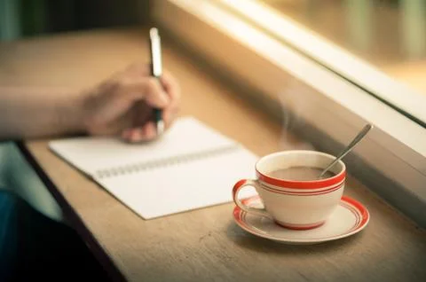 Writing on notebook with coffee cup Stock Photos